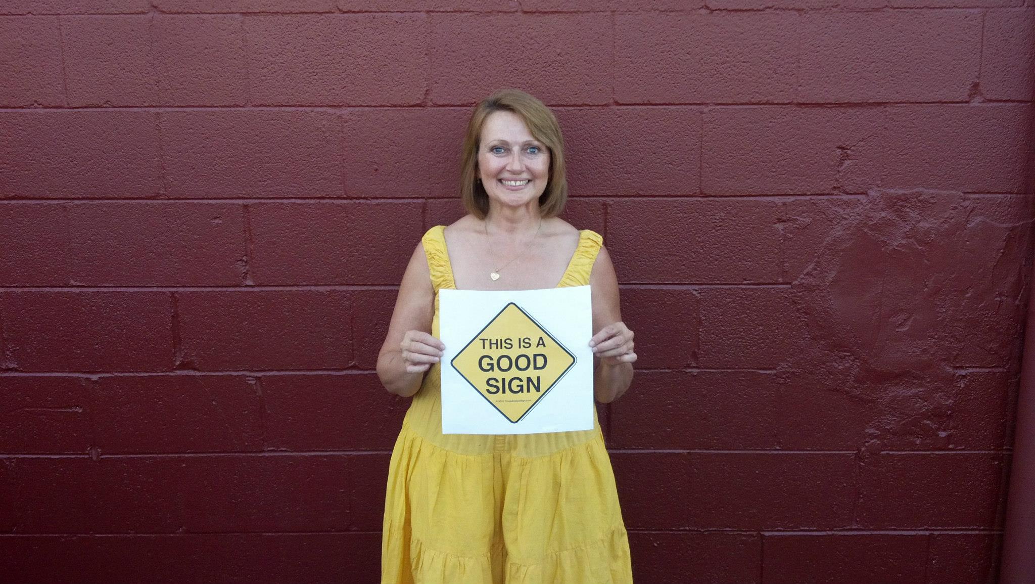 Woman holding Good Sign